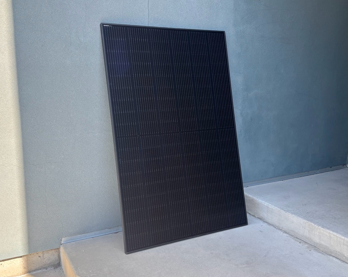 A new all-black Imperial Star 400W solar panel leaning against a wall in Salt Lake City